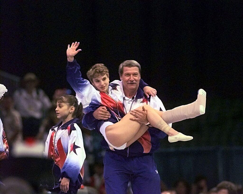 Kerri Strug with her injured ankle, her coach Bela Karolyi holding her